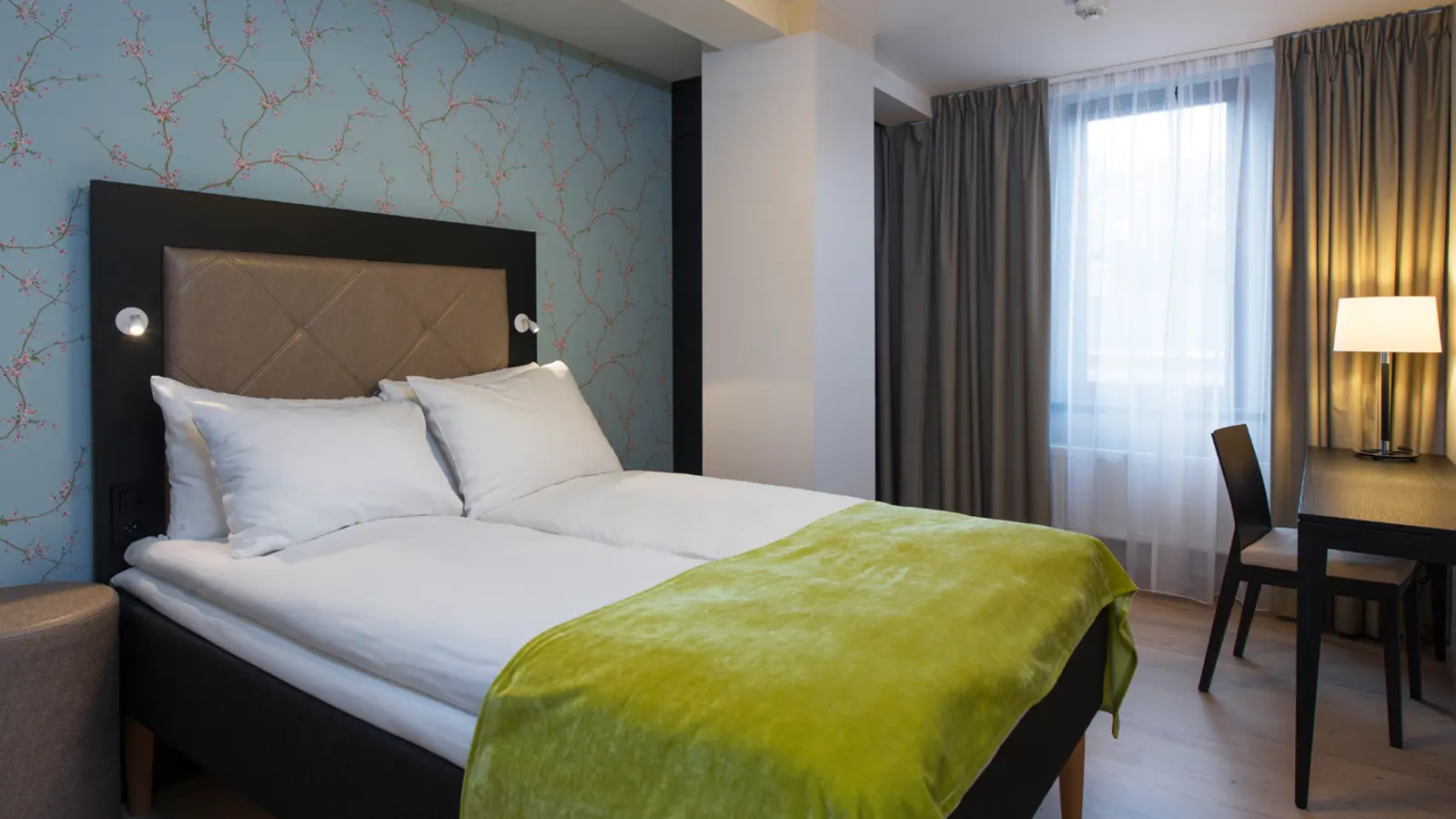Desk and double bed in apartment at Thon Hotel Slottsparken